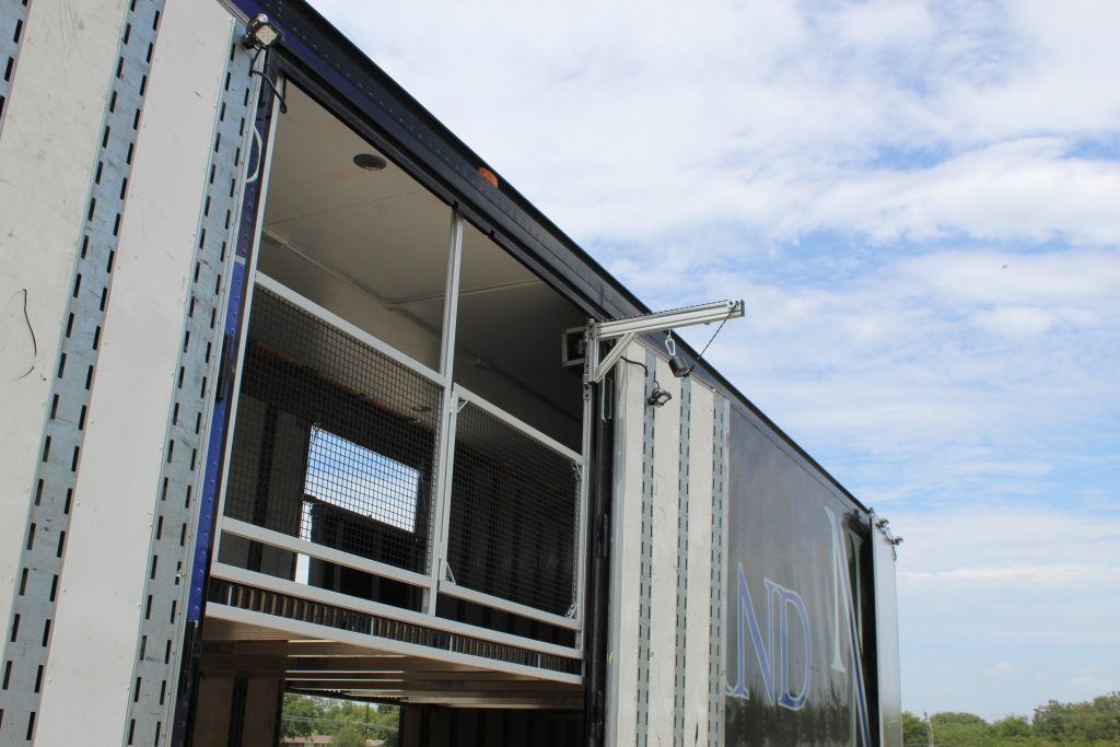 Tuba Lift on North Mesquite High School Semi Trailer with a security gate and fence