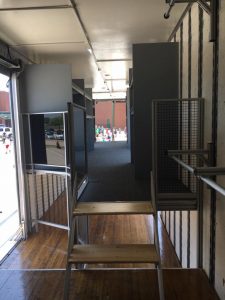 Interior of Lake Dallas High School Marching Band Semi Equipment Trailer. Stairs onto 2nd floor with Custom Instrument Storage and LED Interior Lighting